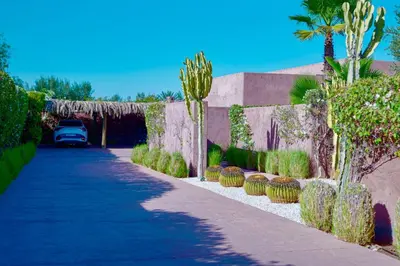a driveway with cacti and plants next to a wall at Royal Palm Luxury Villa Heated Pool Spa in Moussiha