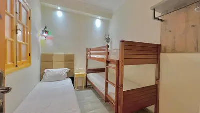 a small room with two bunk beds in it at Cycas family apart ground floor parking in Marrakech