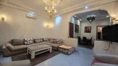 a living room with a couch and a tv at Cycas Family Apart grand wifi parking in Marrakech