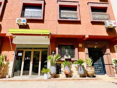 a building with potted plants in front of it at Cycas Family aparts 1 ch salon parking in Marrakech