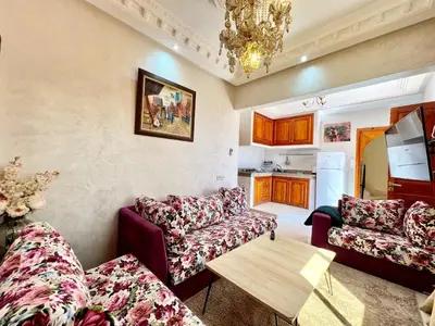 a living room with two couches and a table at Cycas Family aparts 1 ch salon parking in Marrakech