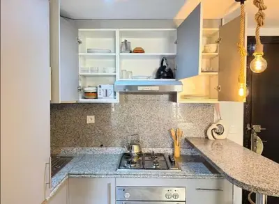 a kitchen with white cabinets and a stove top oven at Maison LINA in Marrakech