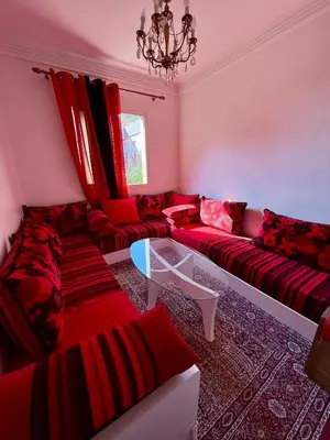 a living room with red couches and a chandelier at Layla Apartment in Marrakech