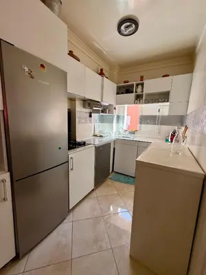 a kitchen with white cabinets and a stainless steel refrigerator at Layla Apartment in Marrakech
