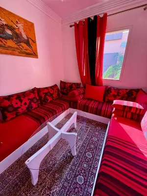 a living room with a red couch and a window at Layla Apartment in Marrakech