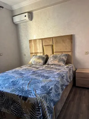 a bedroom with a bed with a blue and white comforter at Appartement bien équipé avec piscine sur Marrakech in Marrakech