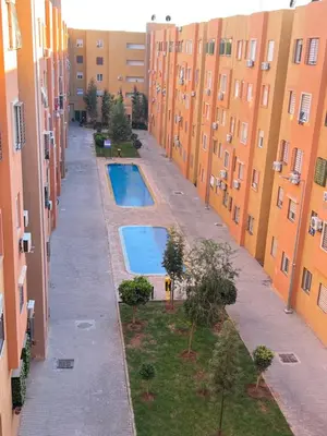 an alley between two buildings with two swimming pools at Appartement bien équipé avec piscine sur Marrakech in Marrakech