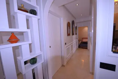 a hallway with white walls and white shelves at Appartement Spacieux Idéal Séjours Longs in Marrakech