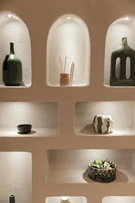 a wall with shelves with vases and a plant at Cosy escape 1BED in central Gueliz With Pool in Marrakech