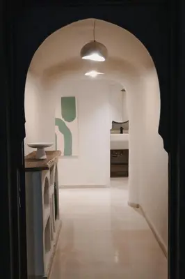 a hallway with an archway with a table and a lamp at City Center 1 BED Apartments - Miramas - Pool and gym in Marrakech