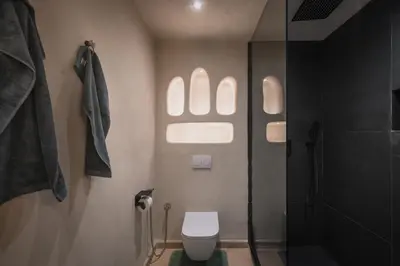 a bathroom with a toilet and a shower with a window at City Center 1 BED Apartments - Miramas - Pool and gym in Marrakech