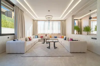 a large living room with white couches and a table at Luxury Villa Hammam Piscine chauffeé sans Vis Avis in El Harkat