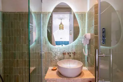 a bathroom with a sink and a glass shower at Riad Janate BAHIA & Spa in Marrakech