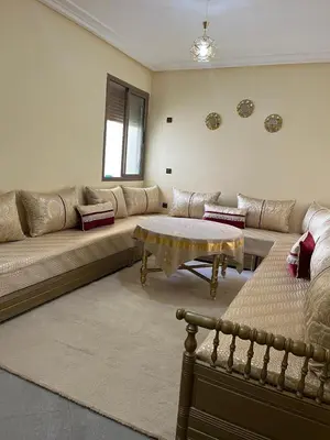 a living room with a large couch and a table at Appartement très bien meublé in Marrakech