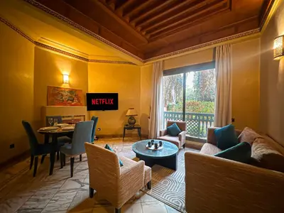 a living room with a couch and a table at le pavillon de la palmeraie - Piscine et jardins in Marrakech