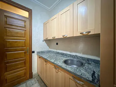 a kitchen with a sink and wooden cabinets at le pavillon de la palmeraie - Piscine et jardins in Marrakech
