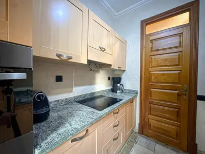 a kitchen with wooden cabinets and a counter top at le pavillon de la palmeraie - Piscine et jardins in Marrakech