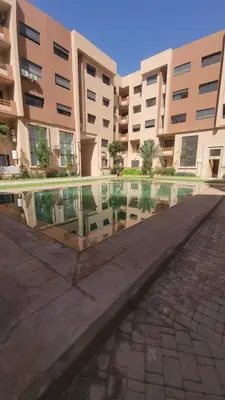 a pool of water in front of a building at Nour Prestige Appartement Moderne Piscines Résidence Sécurisée in Marrakech
