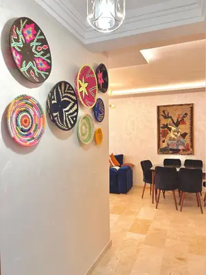 a living room with plates on the wall at Appartement Chic près M Avenue Piscine Balcon in Marrakech