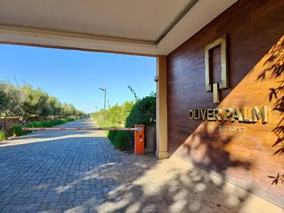 a building with a sign on the side of a street at Duplexe Moderne 3 suites à Oliver Palm Resort in Marrakech