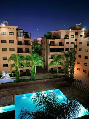 a swimming pool with palm trees in front of buildings at Premium Stay in a Prestigious Residence with a Pool in Marrakech
