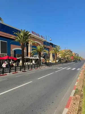 an empty street in front of a building with palm trees at Premium Stay in a Prestigious Residence with a Pool in Marrakech