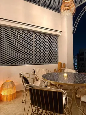 a table and chairs in a room with a table and a table and chairs at Premium Stay in a Prestigious Residence with a Pool in Marrakech