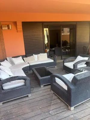 a group of wicker chairs and tables on a patio at Appartement centre Marrakech avec piscine in Marrakech
