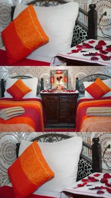 a row of beds with orange and white pillows at Riad Dar Ceramic in Marrakech