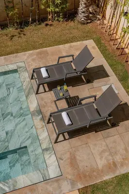 a group of tables and chairs next to a pool at Villa LUMA - Akenza Residence in El Rhechat
