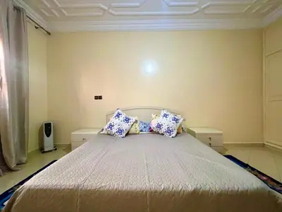 a bedroom with a bed with blue and white pillows at Appartement Kech in Marrakech