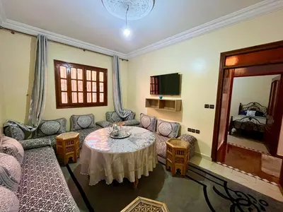 a living room with a table and a couch at Appartement Kech in Marrakech