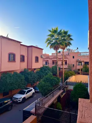 a car parked in a parking lot with a palm tree at Appartement Kech in Marrakech