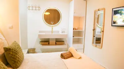 a bathroom with a bed with a mirror and a sink at Victor Hugo Prestige Suite in Marrakech
