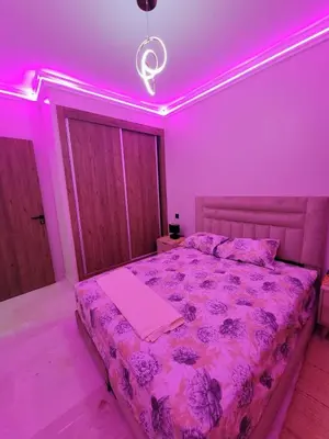 a bedroom with a bed with purple lights on it at Nour prestige Appartement Piscine free Parking in Marrakech