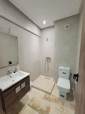 a bathroom with a sink and a toilet and a mirror at Nour prestige Appartement Piscine free Parking in Marrakech