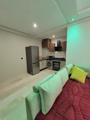 a living room with a couch and a kitchen at Nour prestige Appartement Piscine free Parking in Marrakech