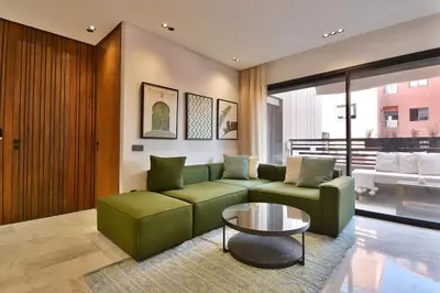 a living room with a green couch and a table at Studio luxueux - centre ville in Marrakech
