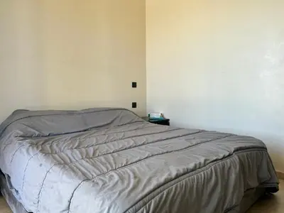 a bedroom with a bed in a white wall at Villa l'odyssée in Marrakech