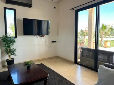 a living room with a flat screen tv on the wall at Villa l'odyssée in Marrakech