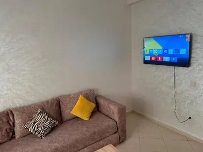 a living room with a couch and a flat screen tv at Quiet &Bright Apartment in Marrakech