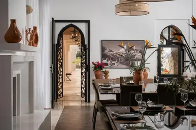 a dining room with tables and chairs and an open door at Villa Montbel in Marrakech