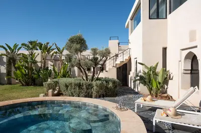 a swimming pool in a yard next to a building at Villa Montbel in Marrakech