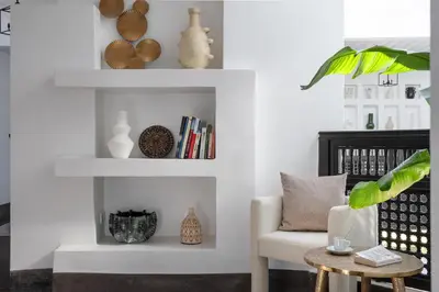 a living room with white shelves and a chair at Villa Montbel in Marrakech