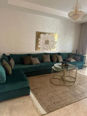 a living room with a green couch and a table at Marrakech Peaceful Escape - Appartement Noria Marrakech in Marrakech