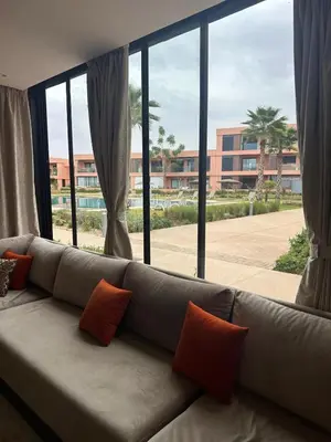 a couch in a living room with a large window at Marrakech Peaceful Escape - Appartement Noria Marrakech in Marrakech
