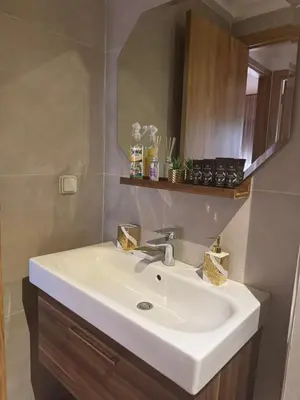 a bathroom with a white sink and a mirror at Marrakech Peaceful Escape - Appartement Noria Marrakech in Marrakech