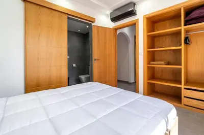 a bedroom with a large white bed and wooden cabinets at Villa Djenna piscine privée sans vis-à-vis in Marrakech
