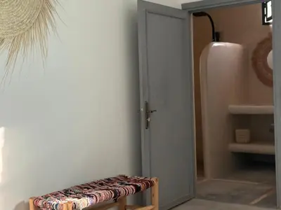 a room with a door and a stool next to a refrigerator at Villa Lalla et Moulay in Marrakech