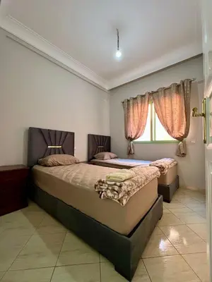a bedroom with two beds and a window at Appartement allal el fassi in Marrakech